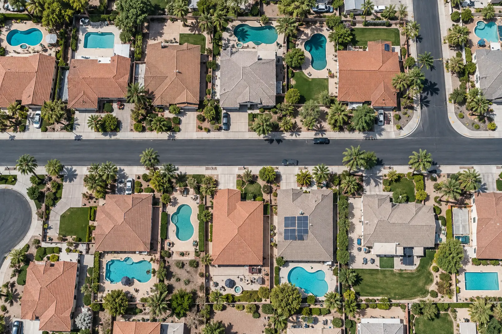 Aerial view of a suburb with many backyard swimming pools
