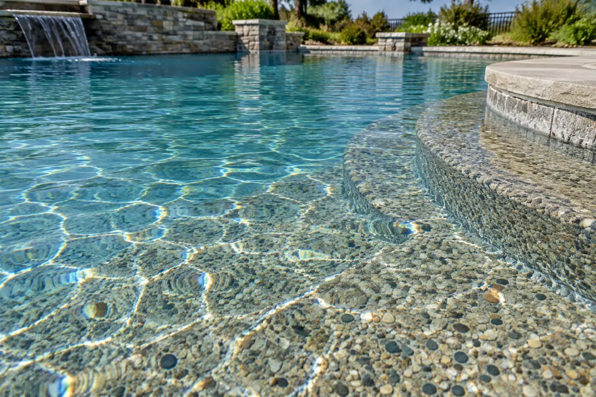 A pebble finish uses smooth, rounded stones set in cement; HomeGuide gives it 15 to 20 or more years of life.