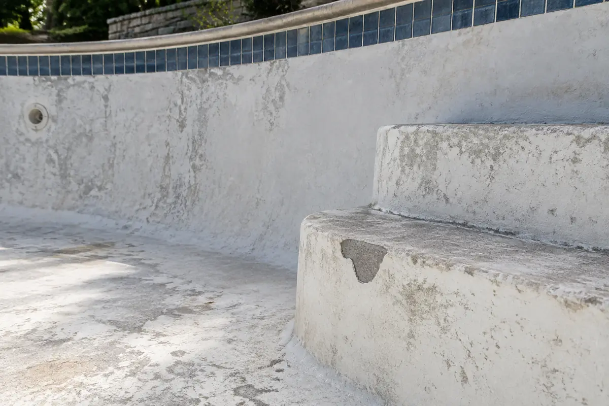 Etched, stained plaster near a step: a common sign that a finish is near the end of its life.